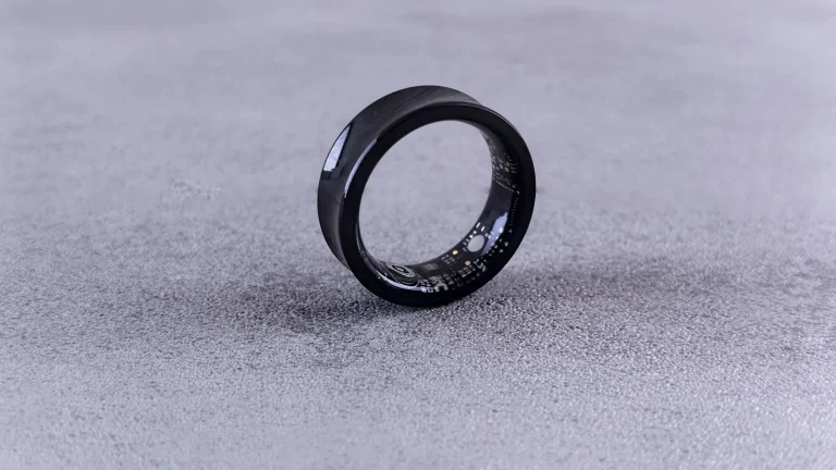 Bague connectée noire posée sur une surface grise