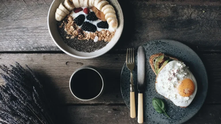 Petit-déjeuner avec bol d'avoine aux fruits, tartine à l'avocat et à l'œuf