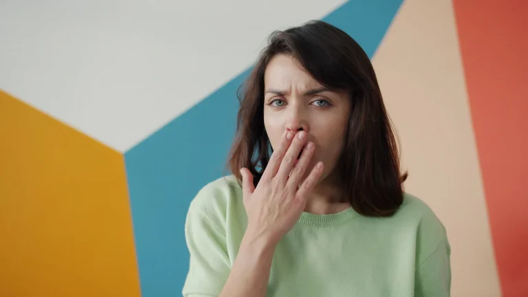 Femme fatiguée qui bâille, la main devant la bouche