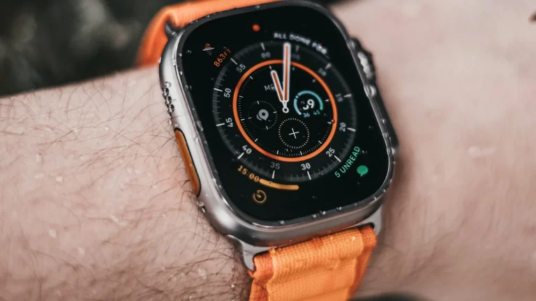 Poignet portant une montre connectée sportive à bracelet orange