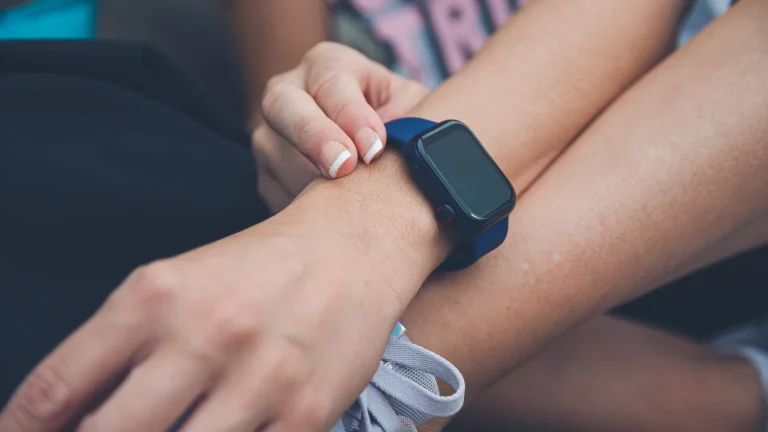 Femme qui ajuste sa montre connectée au poignet avant l'effort