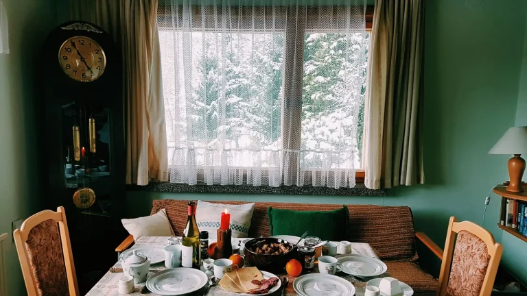 Salle à manger avec table dressée et horloge comtoise au mur