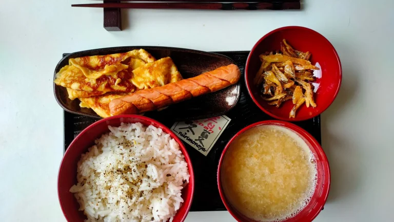 Plateau-repas japonais avec bol de riz, soupe miso, omelette et baguettes