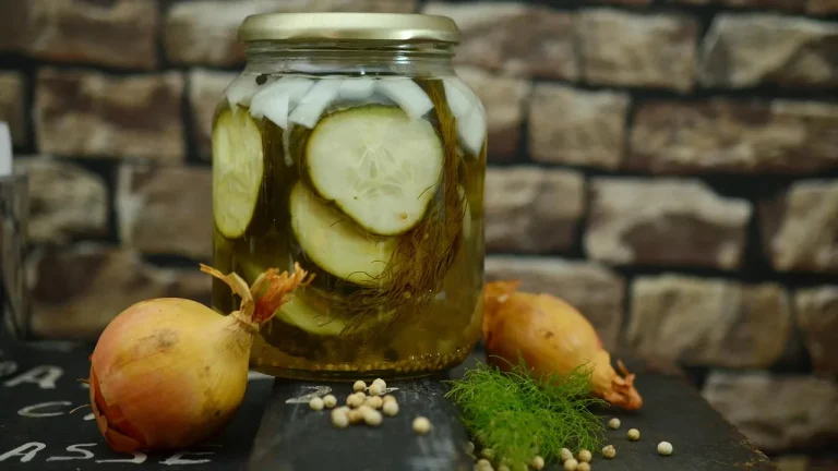 Bocal de cornichons fermentés avec oignons, aneth et graines sur une table
