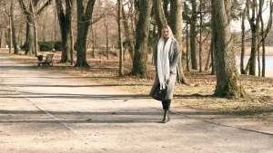 Femme se promenant tranquillement sur l'allée d'un parc, entre les arbres