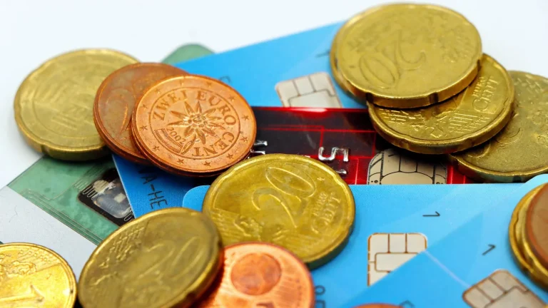 Pièces de monnaie en euros éparpillées sur des cartes bancaires