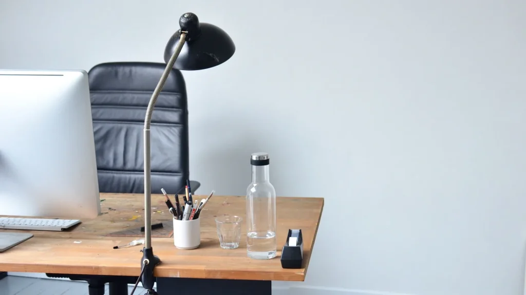 Bureau vide avec lampe articulée, pot à crayons et carafe d'eau, un jour sans travail