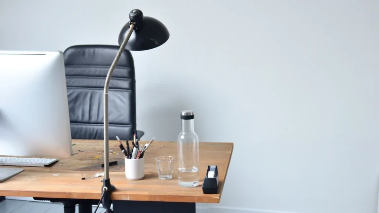 Bureau vide avec lampe articulée, pot à crayons et carafe d'eau, un jour sans travail