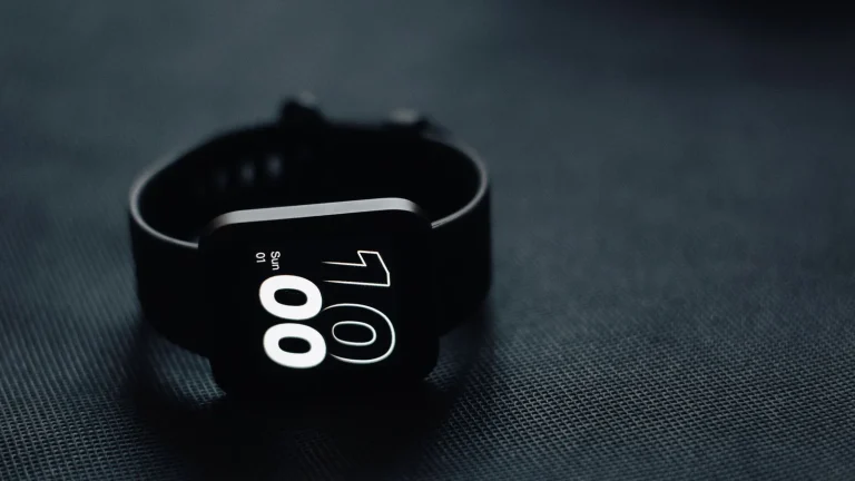Bracelet connecté noir de suivi du sommeil posé sur un tissu sombre
