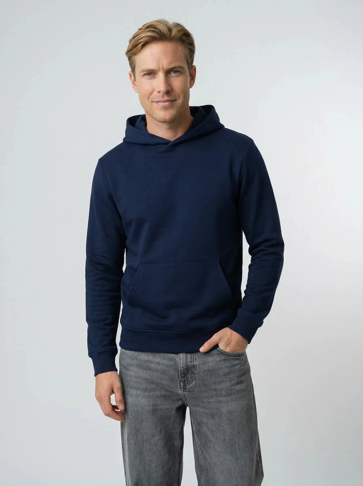 Homme portant un hoodie bleu marine en coton biologique, main en poche